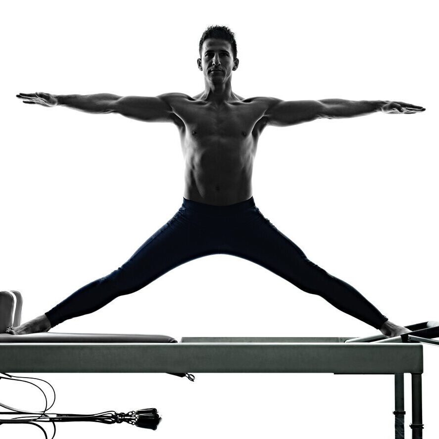A man is doing yoga on the top of a bench.